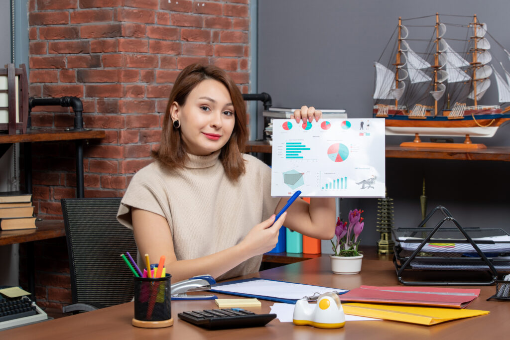 Mulher analisando diagramas de Marketing de Performance no escritório.